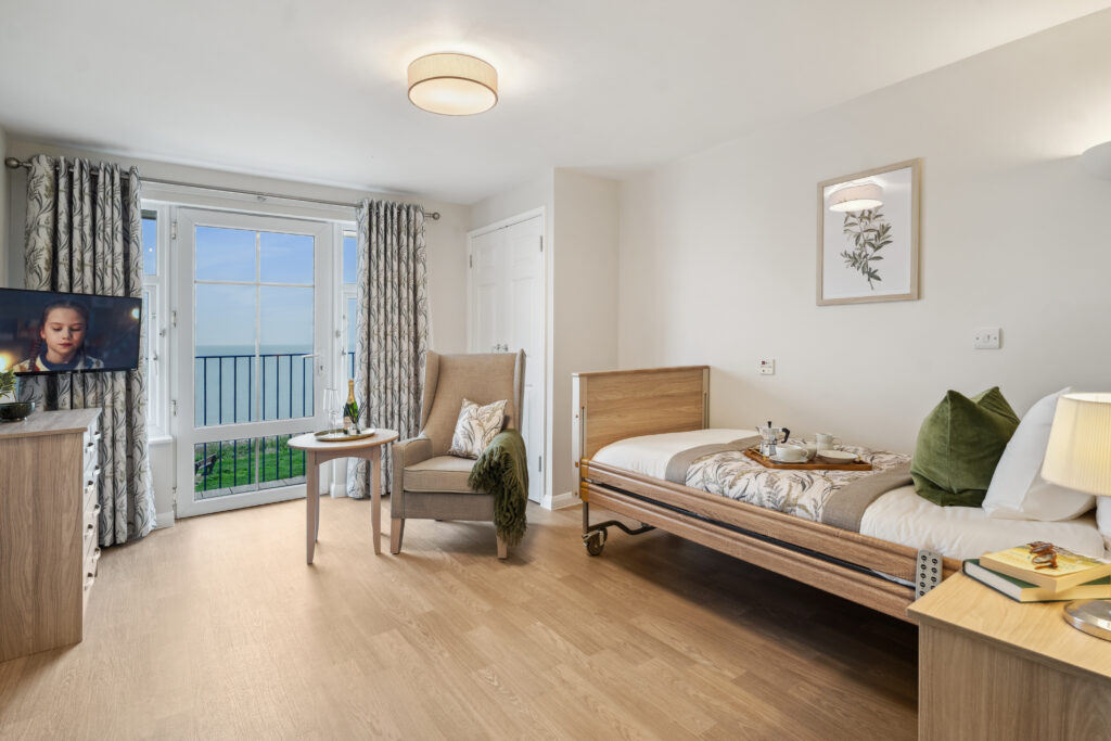 Wider view of bedroom with TV, radio and bed at Island Sands residential care home