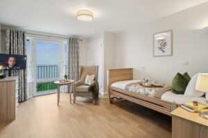 Wider view of bedroom with TV, radio and bed at Island Sands residential care home