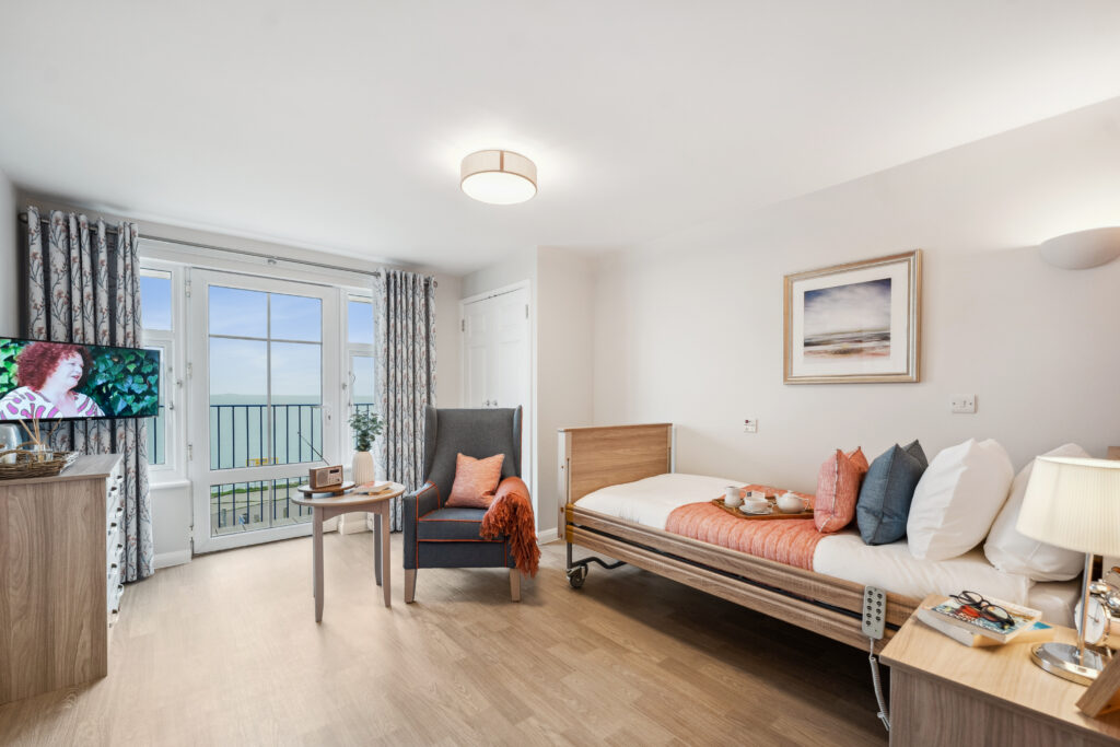 Wider view of bedroom with TV, radio and bed at Island Sands residential care home